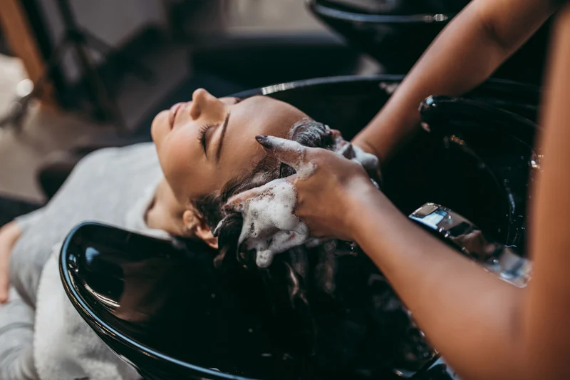 Client's hair being washed at a salon sink.